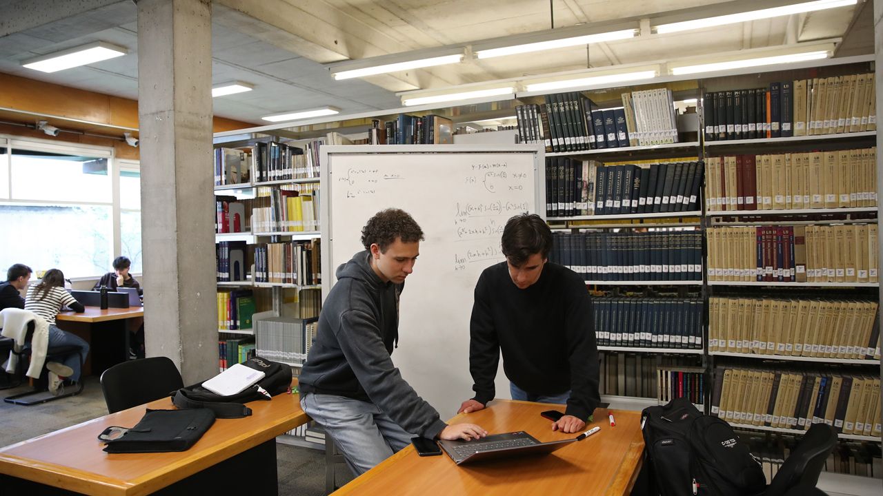 Imagen de estudiantes trabajando en un computador