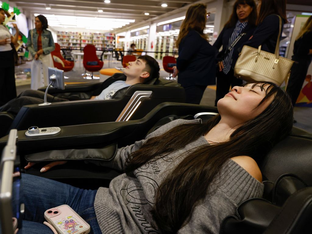 En la imagen se ven dos personas sentadas, cada una en un sillón de relajación. Están con los ojos cerrados, se percibe que disfrutan del momento
